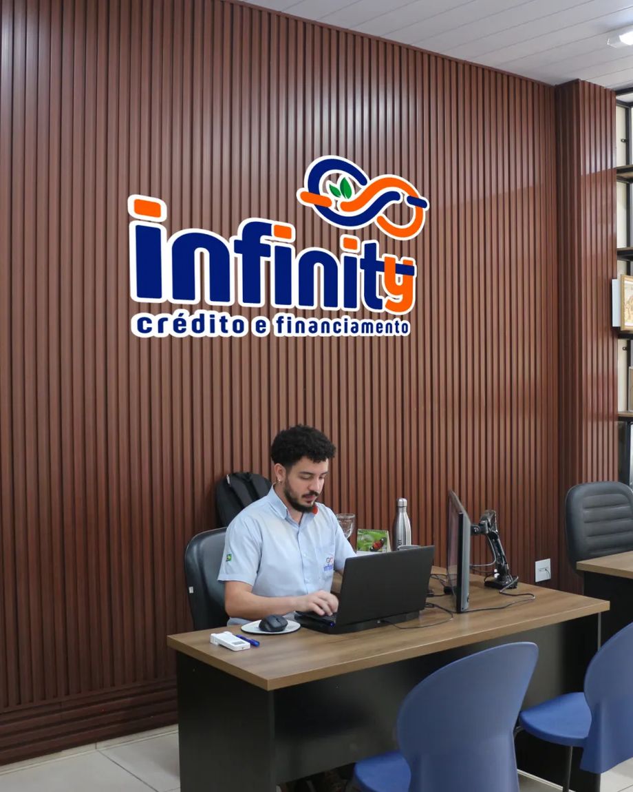 Escritório da Infinity Crédito e Financiamento, em Uberlândia, com o logo na parede de madeira